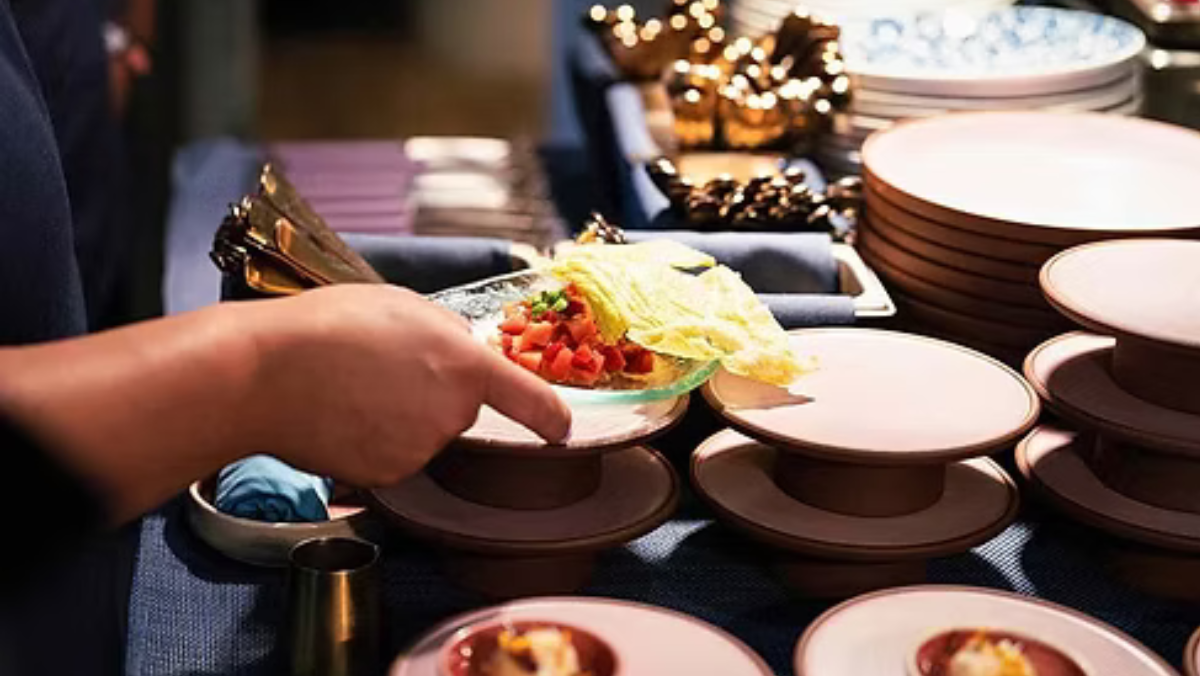 Chef plating dish featuring cultivated salmon on restaurant plates