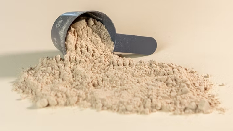 Scoop of protein powder spilled on surface